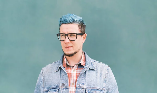 Primer plano retrato de calle chico con pelo azul en chaqueta vaqueros sobre fondo de pared azul. — Foto de Stock