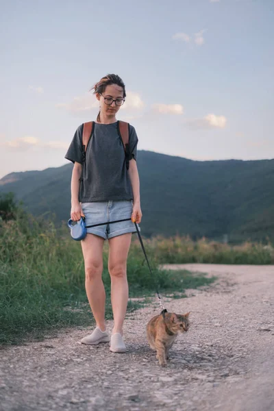 Mujer caminando con un gato en el sendero de la naturaleza. — Foto de Stock