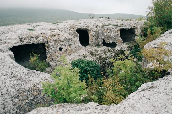 Fragmentos de habitaciones talladas en la roca en la ciudad de montaña de Eski-Kermen. —  Fotos de Stock
