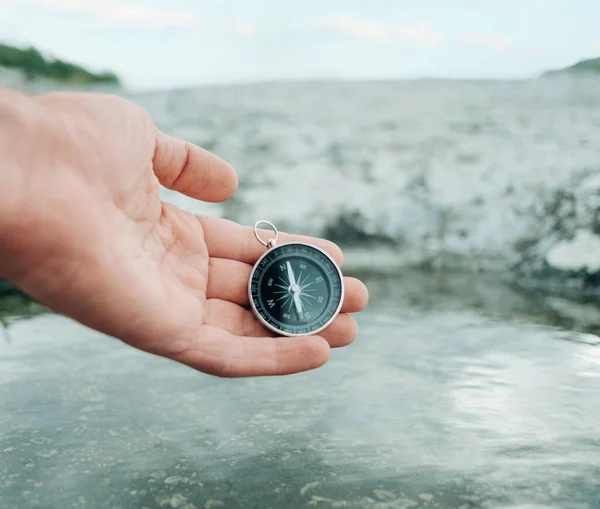 Man holds a compass near the river bank. —  Fotos de Stock