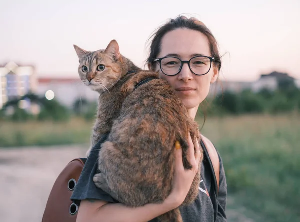 Женщина гуляет с котом в городском парке в летний вечер. — стоковое фото