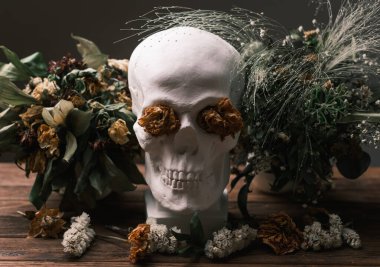 Kurumuş çiçekler ve kafatasıyla romantik Gotik bir hayat.