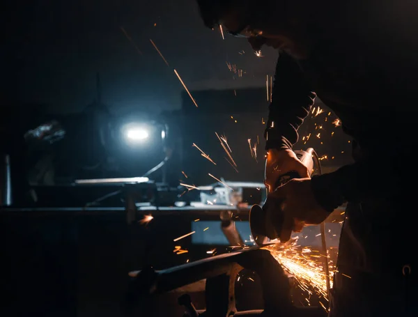 Worker cuts metal with a circular saw, sparks fly to the sides.