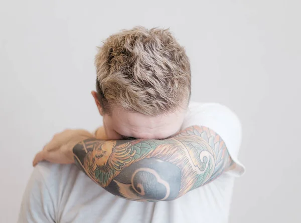 Portret młodego mężczyzny z tatuażem na ramieniu. — Zdjęcie stockowe