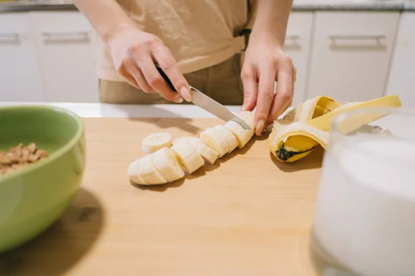 Donna che taglia una banana per colazione. — Foto Stock