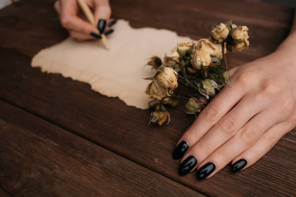 Vrouw handen schrijven iets op een vintage papier. — Stockfoto