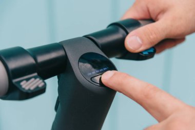 Sokakta scooter 'ı açan ya da kapatan bir adam..