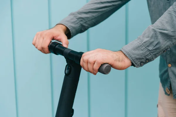 Close-up nas mãos de um jovem que está segurando o volante de uma scooter elétrica. — Fotografia de Stock