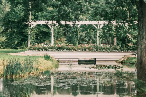 Wandelbrug over een vijver in een zomerpark — Stockfoto