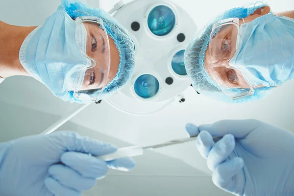 Infermiera femminile passa un bisturi al chirurgo — Foto Stock