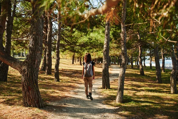 Ragazza con zaino a piedi nel parco — Foto Stock