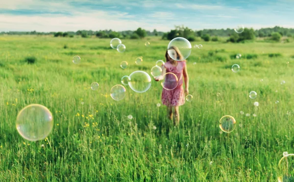 Fille avec bulles de savon sur prairie — Photo