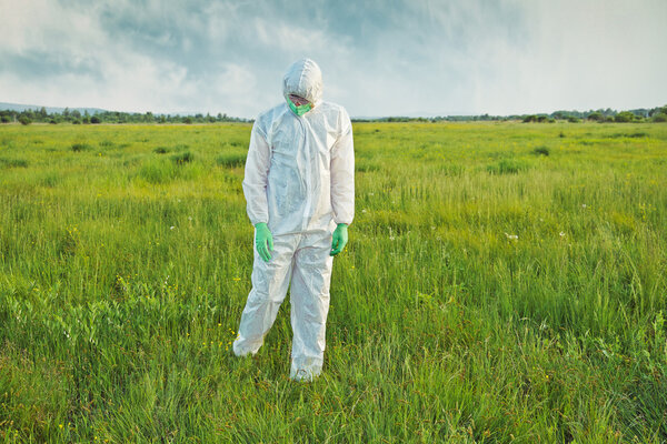Scientist in uniform analyzing grass