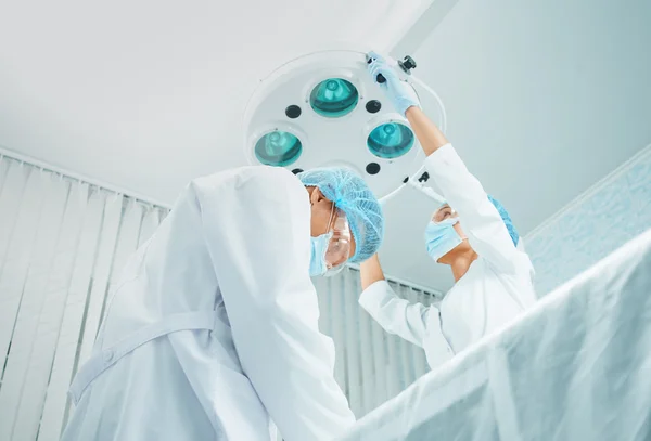 Serious man surgeon and female assistant — Stock Photo, Image