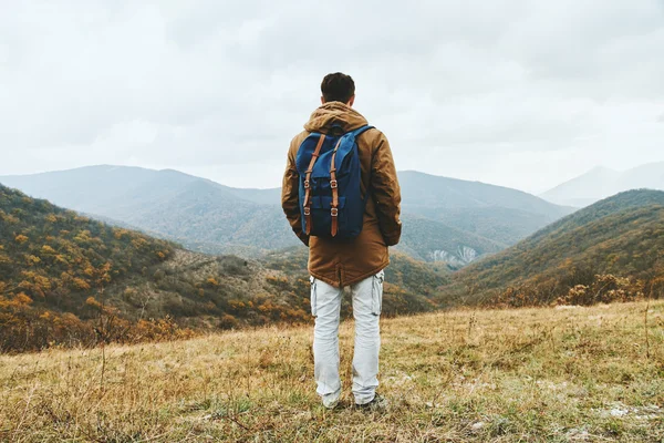 Hiker man med ryggsäck i bergen — Stockfoto