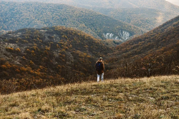 Человек, идущий по осенним горам — стоковое фото