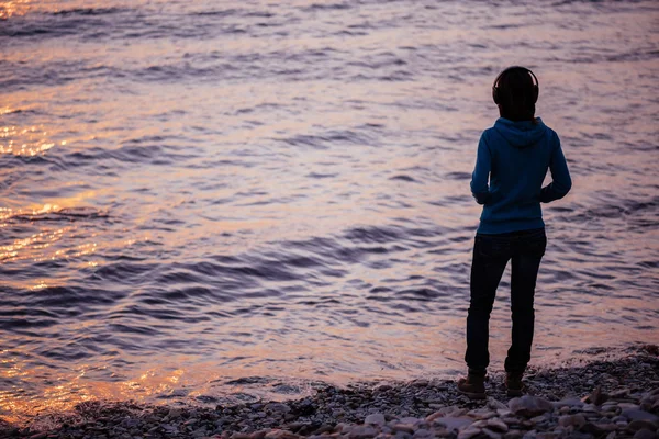 Dziewczyna w słuchawkach na plaży — Zdjęcie stockowe