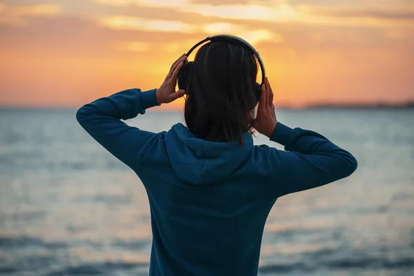 Woman in headphones over sea — Stock Photo, Image