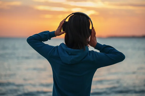 Vrouw in hoofdtelefoons over zee — Stockfoto