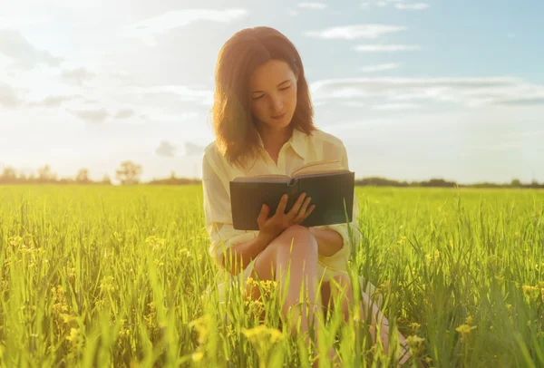 Vrouw leesboek op weide — Stockfoto