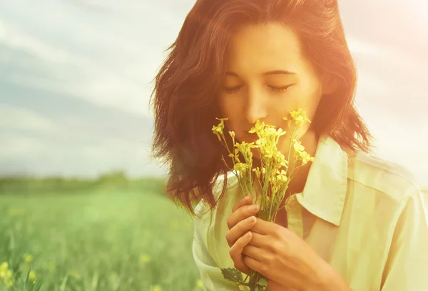 Femme sentant les fleurs en été — Photo