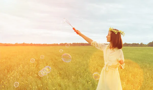 Woman blowing soap bubbles — Stock Photo, Image