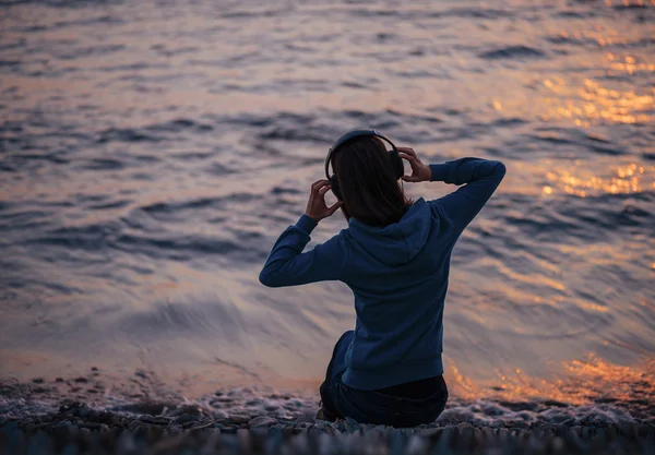 Femme écoute de la musique sur la plage — Photo