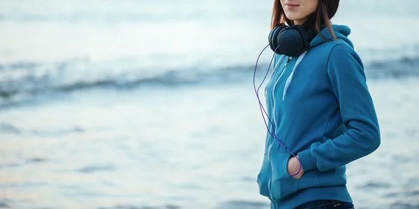 Dziewczyna z słuchawkami na wybrzeżu — Zdjęcie stockowe
