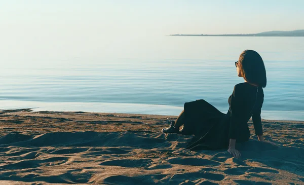 Lány ül a strandon — Stock Fotó