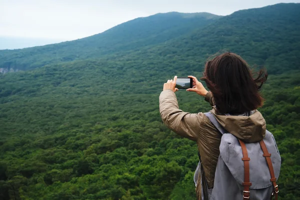 Женщина фотографирует горный пейзаж — стоковое фото