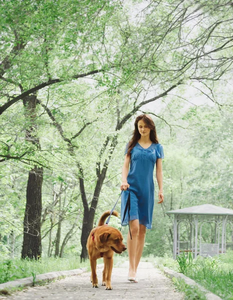 Jonge vrouw met een hond wandelen — Stockfoto