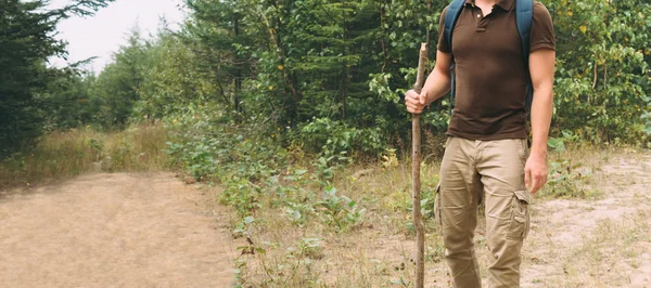 Hiker man walking with a wooden stick — Stock Photo, Image