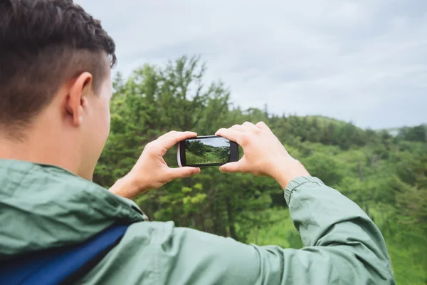 Caminante tomando fotografías del paisaje — Foto de Stock