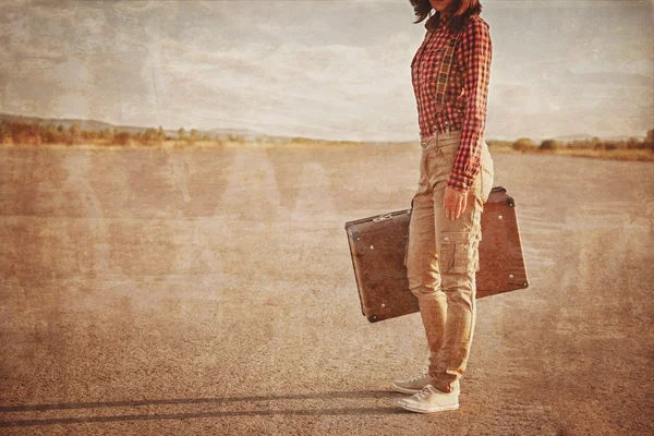 Женщина с чемоданом на дороге — стоковое фото