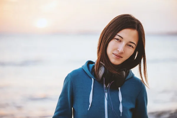 Frau mit Kopfhörer ruht sich an Küste aus — Stockfoto