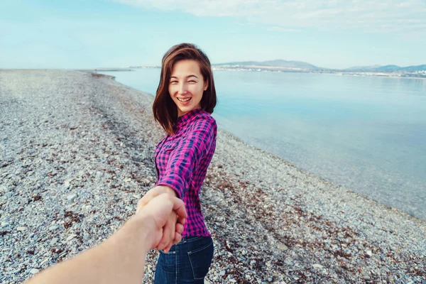 Frau führt Mann am Strand an — Stockfoto