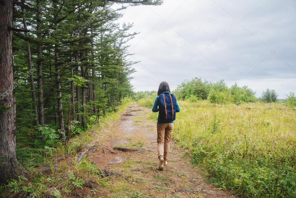 Girl walking on footpath in summer forest