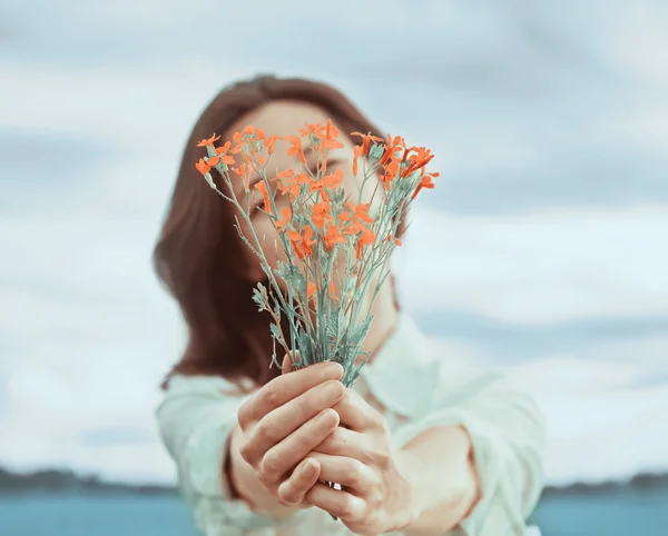 Mulher segura buquê de flores silvestres vermelhas — Fotografia de Stock