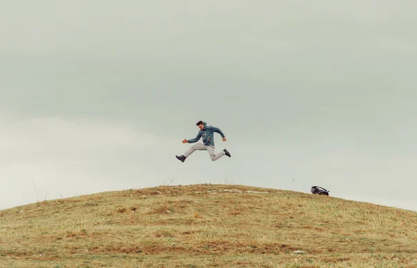 Happy man jumping on mountain