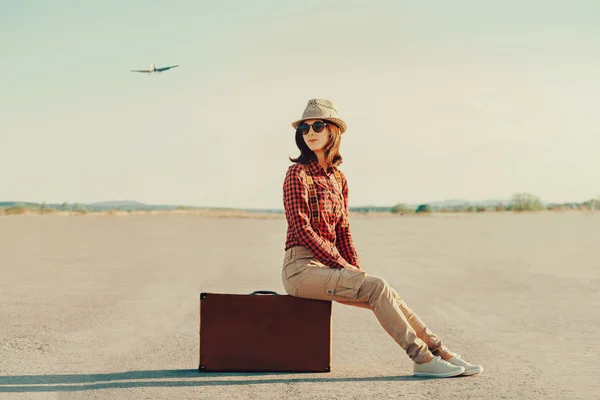 Traveler woman sitting on suitcase — Stock Photo, Image