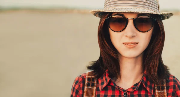 Beautiful young woman in sunglasses and hat — Stock Photo, Image
