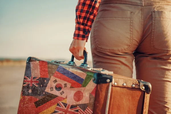 Traveler with suitcase with different flags — Stock Photo, Image