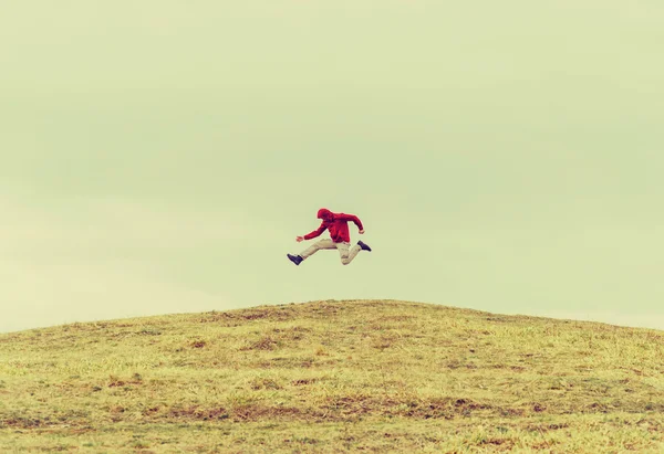 Happy traveler jumping on hill — Stock Photo, Image