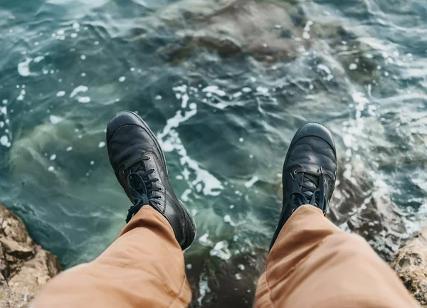 Hombre sentado en piedra sobre el mar —  Fotos de Stock
