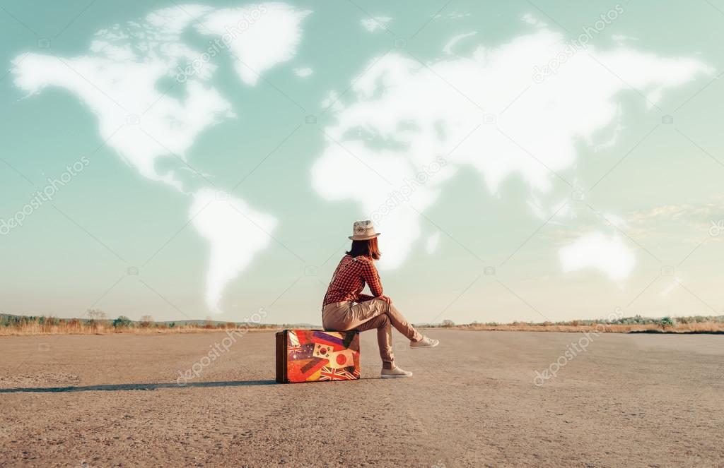Traveler girl sitting on suitcase