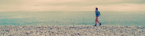 Dívka s batohem, chůze na pláž — Stock fotografie