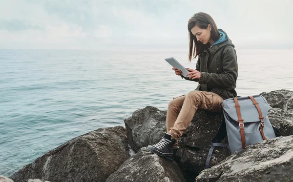 Dijital tablet ile kıyısında oturan kadın — Stok fotoğraf