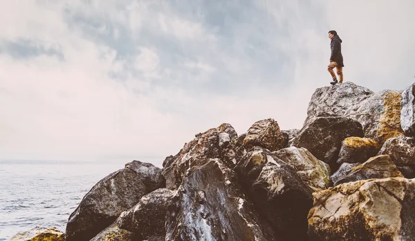 Mujer de pie sobre piedra cerca del mar — Foto de Stock