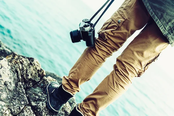 Žena s starý fotoaparát stojí na pobřeží — Stock fotografie