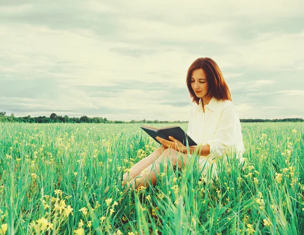 Donna che legge libro sul prato estivo — Foto Stock